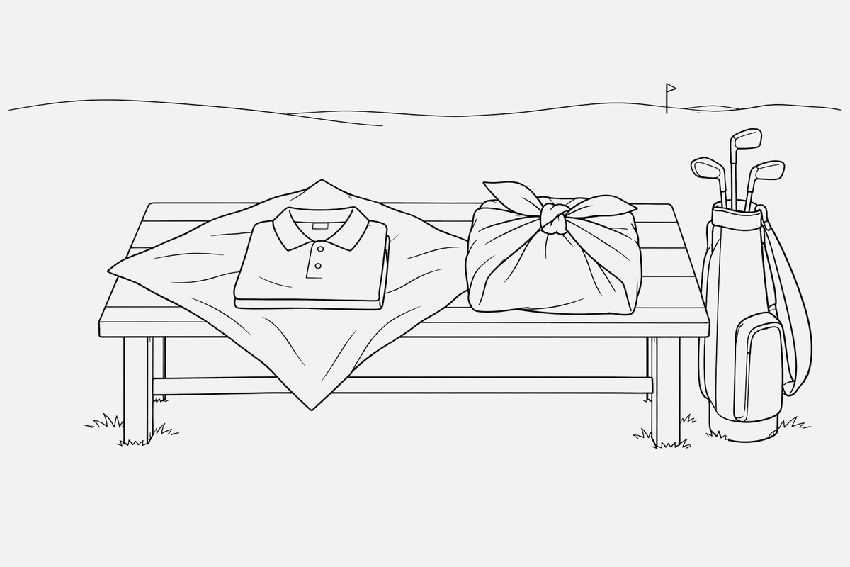 Black line illustration of a folded golf shirt on an open furoshiki cloth beside a tied fabric parcel and golf bag.