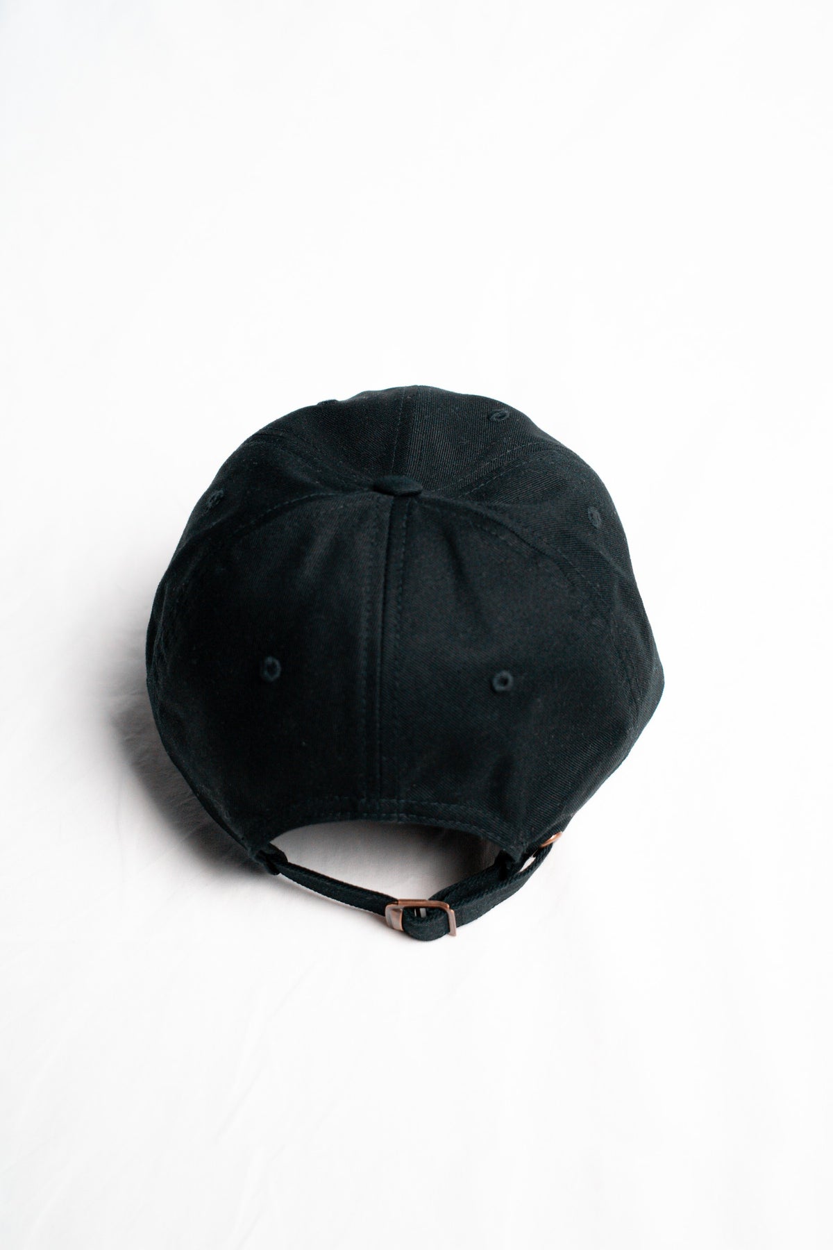 FOA black cap, rear view showing the adjustable strap and buckle.