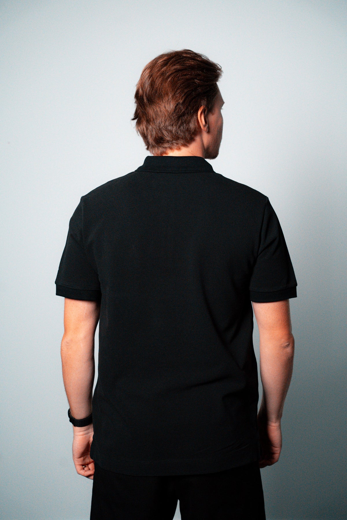 FOA black polo, back view worn on a model.