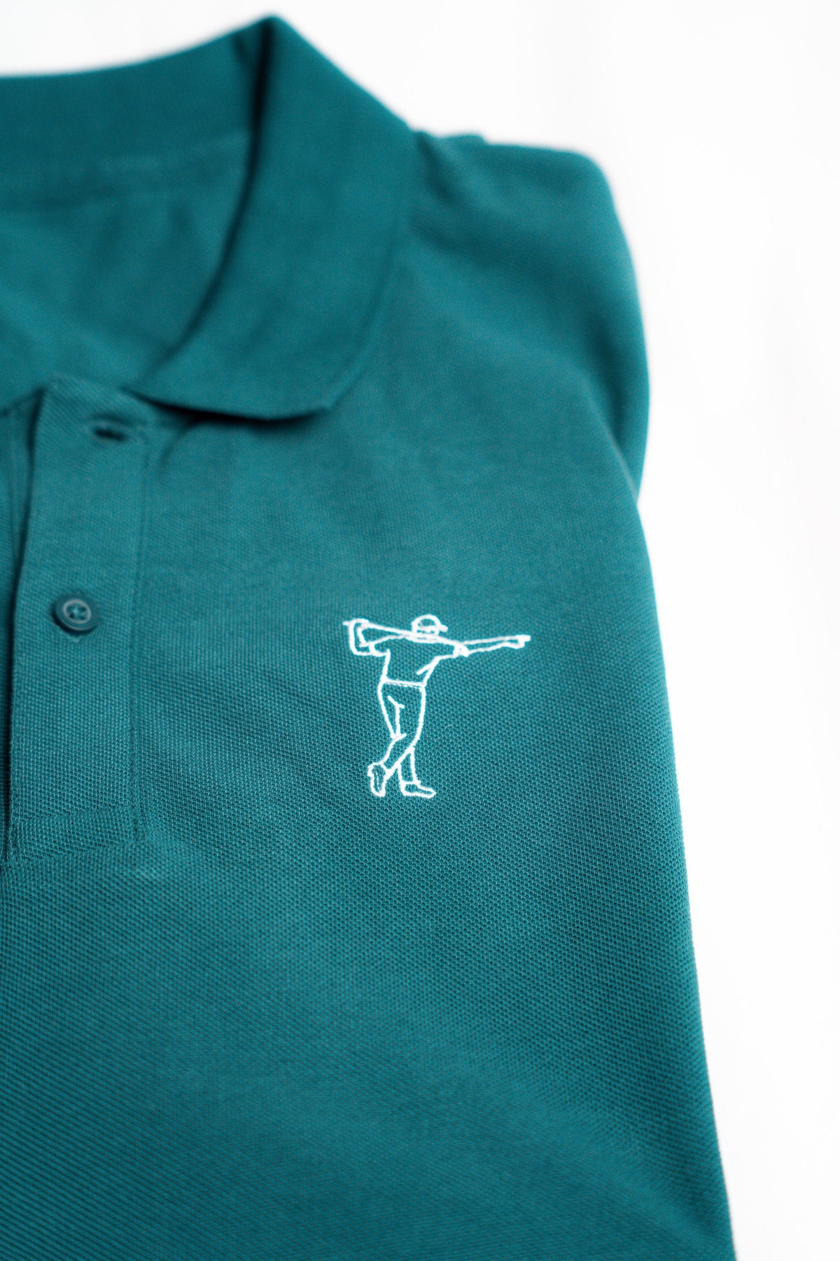 FOA green polo, close-up of the embroidered golfer and fabric.