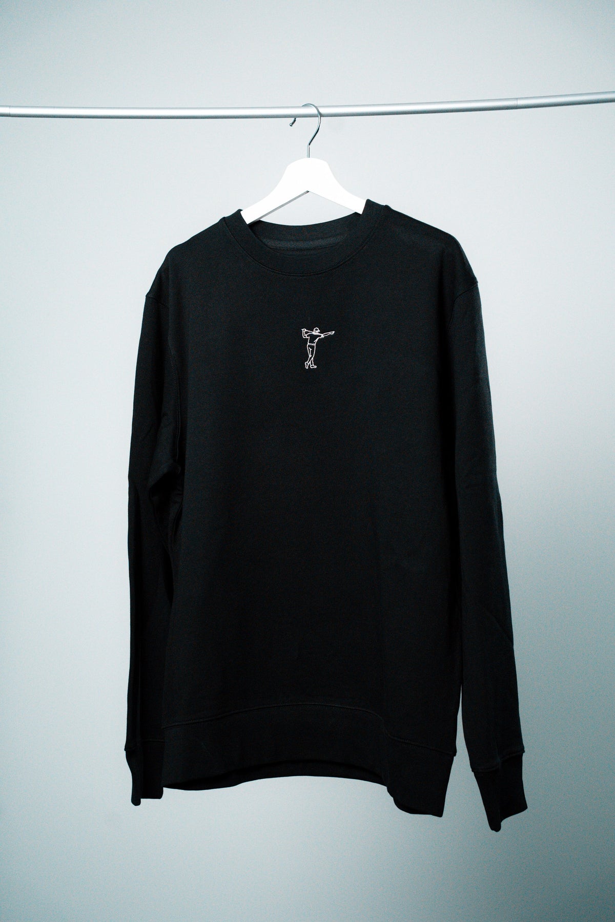FOA sweatshirt, svart, framifrån på en galge.