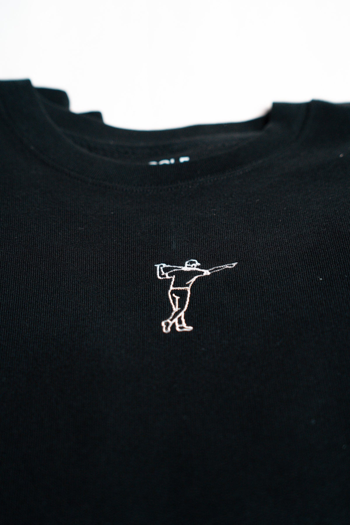 FOA black sweatshirt, close-up of the embroidered golfer and fabric.