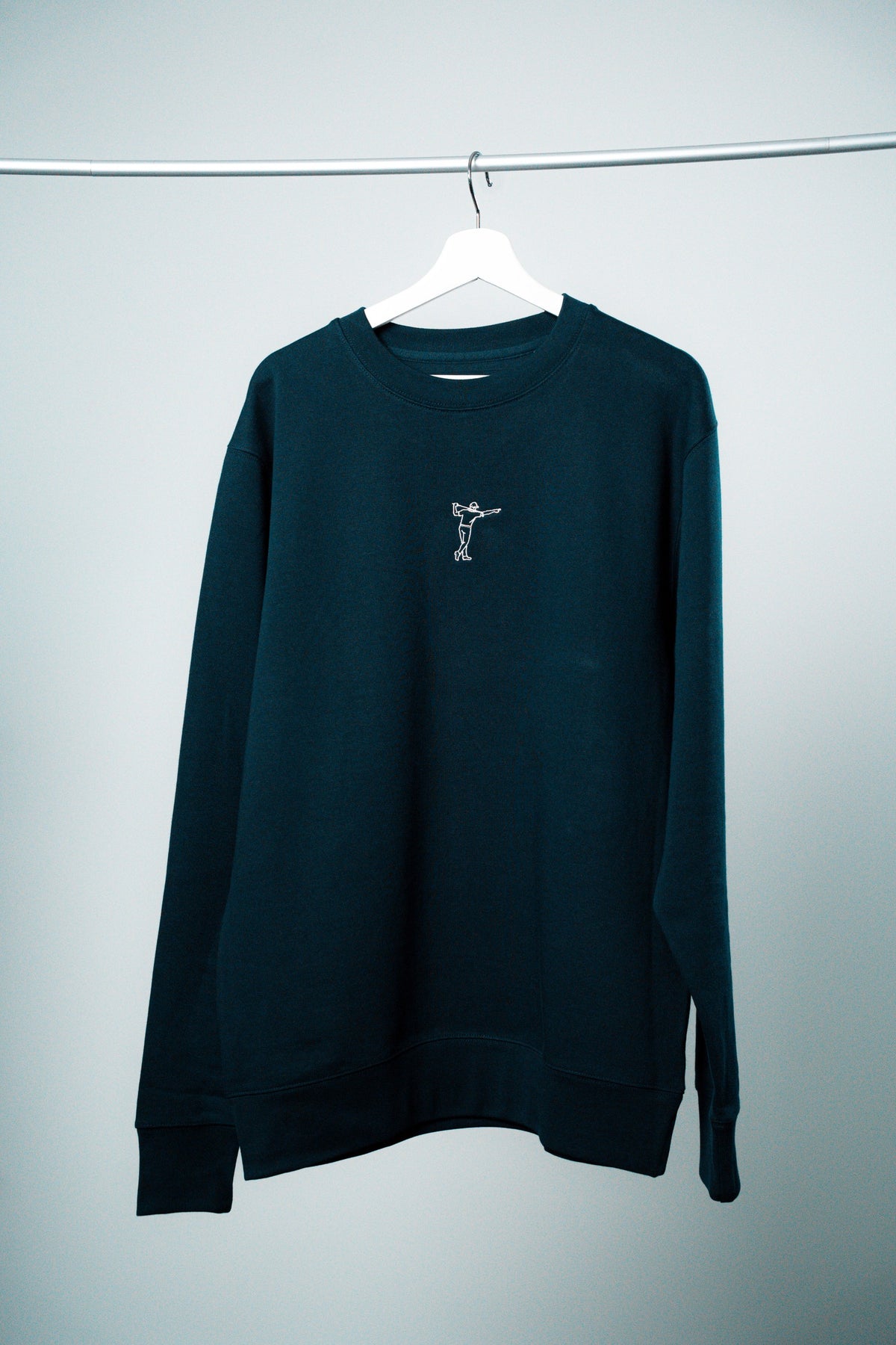 FOA sweatshirt, marinblå, framifrån på en galge.